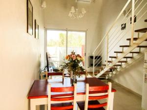 een eetkamer met een tafel met een vaas met bloemen bij Apartamento Duplex del Botanico in Villa Elisa