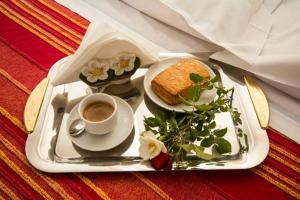 una bandeja con un sándwich y una taza de café en B&B La Dimora delle Calendule, en Virgilio