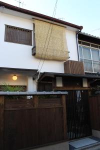 a house with a fence and a wooden garage at Guesthouse Higashiyama Jao in Kyoto