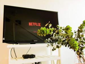 - une télévision à écran plat assise sur une table blanche dans l'établissement Apartamento, à Villa Elisa