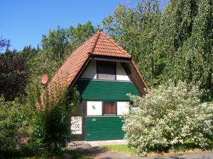una pequeña casa verde y blanca con techo rojo en Ferienhaus Kirschblüte, en Ronshausen