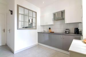 a kitchen with white cabinets and a window at Résidence Estienne d'Orves in Nice