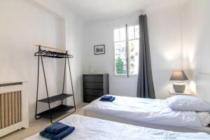 1 dormitorio con 2 camas y ventana en Résidence Estienne d'Orves, en Niza