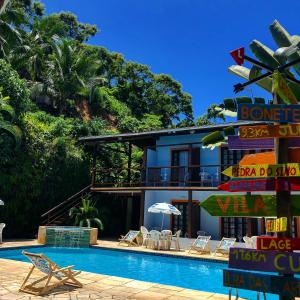 um resort com piscina e cadeiras e um edifício em Residencial Vilamar em Ilhabela