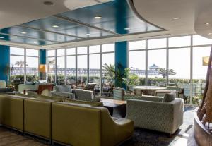 a lobby with couches and tables and large windows at Tides Folly Beach in Folly Beach