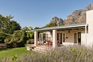 
a large white house with a patio and trees at Boschendal Farm Estate in Franschhoek

