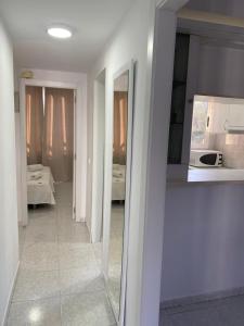 ベニドルムにあるTropic Mar 2Hの鏡付きの廊下とキッチンが備わる客室です。