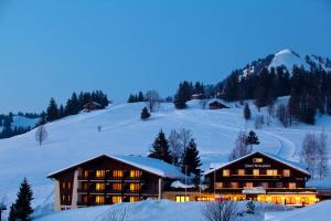 un lodge en la nieve por la noche con nieve en Hotel Arvenbüel, en Amden