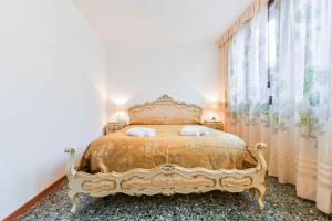 ein Schlafzimmer mit einem Goldbett mit zwei Kissen in der Unterkunft Ca Virgilio in Venedig