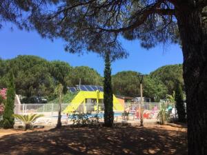 a playground with a yellow slide in a park at Budget Glamping Safaritent - Mas de Mourgues in Vauvert