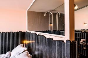 ein Schlafzimmer mit einem großen Spiegel über einem Bett in der Unterkunft Hôtel La Reine Jane in Hyères