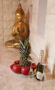 un plato de fruta junto a un buddha y una estatua de oro en Luxury Suite, en Rímini