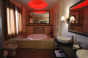 a bathroom with a tub and two sinks and a mirror at Luxury Suite in Rimini