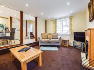 uma sala de estar com um sofá e uma mesa em Queen Mary em Winchcombe