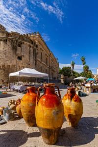 a group of vases lined up in front of a building at Palazzo Cariddi Apartment in Nardò