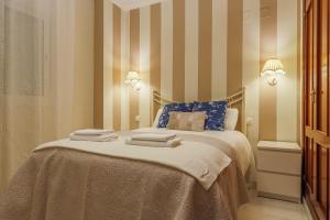 a bedroom with a bed with towels on it at Descanso-elegancia en Sevilla Parking Gratuito in Seville