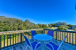 a patio with a table and chairs on a deck at East of the Sun Beachside Apartment with Deck! in Emerald Isle
