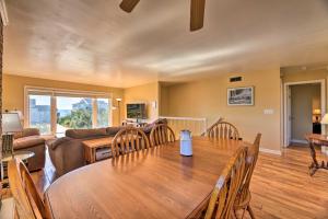 a living room with a wooden table and a couch at East of the Sun Beachside Apartment with Deck! in Emerald Isle