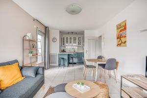 ein Wohnzimmer mit einem Sofa und einem Tisch in der Unterkunft Le First by Cocoonr in Nantes
