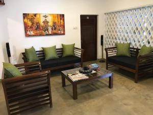 Sala de estar con 2 sofás y mesa de centro en Dions Guest House, en Negombo