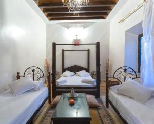 a bedroom with two beds and a table at Riad Oussari in Marrakesh