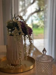 um vaso com flores sobre uma mesa com uma vela em Αgrilitsa House em Vasilítsion