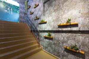 Hutan Melintang的住宿－Top Garden Hotel，墙上有盆栽植物的楼梯