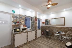 a kitchen with white cabinets and a brick wall at ViOletta in Lido di Ostia