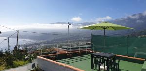 a tennis court with a table and an umbrella at Vistas para el relax in Puntallana