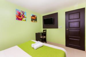 a bedroom with a bed and a door and a television at Hotel Avexi Suites By GEH Suites in Cartagena de Indias