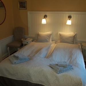a hotel room with a bed and two lamps at Lilla Hotellet i Nora in Nora