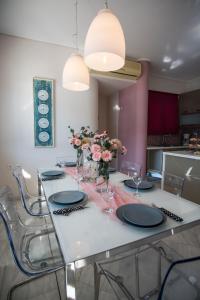 einen Esstisch mit Tellern und Blumen darauf in der Unterkunft Velanidia Apartments in Plataria