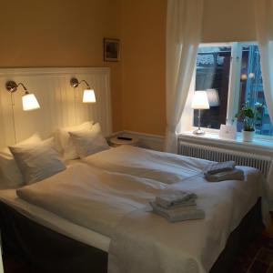 a hotel room with a bed and two lamps at Lilla Hotellet i Nora in Nora