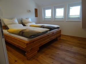 a large bed in a room with two windows at Ferienwohnungen Schwarzwaldtraum in Unterkirnach