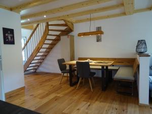 un comedor con mesa y sillas y una escalera en Ferienwohnungen Schwarzwaldtraum, en Unterkirnach