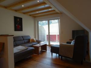 a living room with a couch and a tv at Ferienwohnungen Schwarzwaldtraum in Unterkirnach