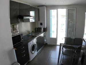 uma cozinha com uma máquina de lavar roupa e uma máquina de lavar roupa em LA TERRASSE DE SAINT-JEAN em Ajaccio