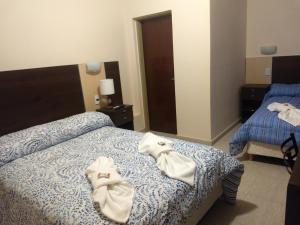 um quarto de hotel com duas camas com toalhas em hotel andino em La Rioja