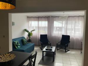 a living room with a couch and chairs and a table at Studio Moderne, Centre Ville Marigot in Marigot