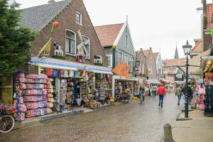 a street with shops and people walking down the street at Boutique hotel The Old Bridge, Volendam in Volendam