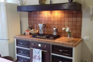 cocina con fogones y pared de azulejos en Casa Lilu, Pietralunga, Umbria, en Pietralunga
