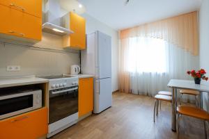 a kitchen with orange cabinets and a table at OK! Советская 98 №1 in Tomsk