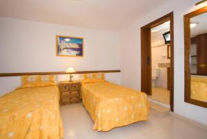 een slaapkamer met 2 bedden en een spiegel bij 4 bedroom Villa Saturn with private heated pool in Puerto del Carmen