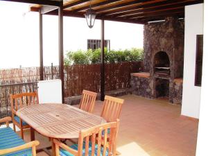 eine Terrasse mit einem Tisch und Stühlen sowie einem Pizzaofen in der Unterkunft 4 bedroom Villa Saturn with private heated pool in Puerto del Carmen