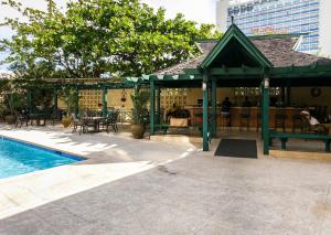 um pavilhão ao lado de uma piscina com mesas e cadeiras em Courtleigh Hotel & Suites em Kingston