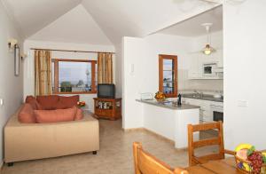 ein Wohnzimmer mit einem Sofa und einer Küche in der Unterkunft 4 bedroom Villa Saturn with private heated pool in Puerto del Carmen