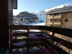 een balkon met een tafel en stoelen en een berg bij Orcières Rond point des Pistes, Front de neige in Orcières