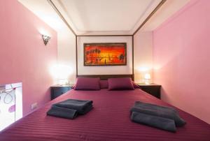 a bedroom with a large bed with purple sheets and pillows at Vita Partenopea in Naples