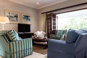a living room with two chairs and a television at Oyster Cottage in Durban