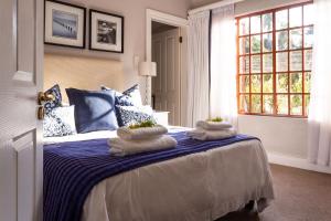 a bedroom with a bed with towels on it at Oyster Cottage in Durban